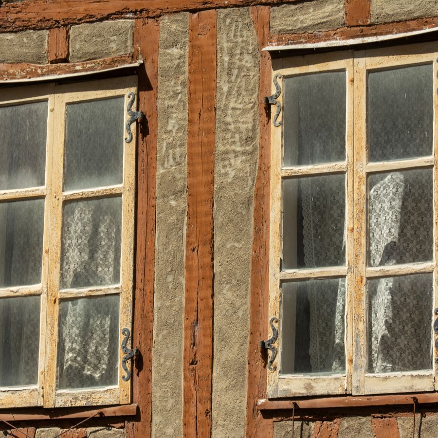Alte Holzfenster an der Fassade eines historischen Gebäudes