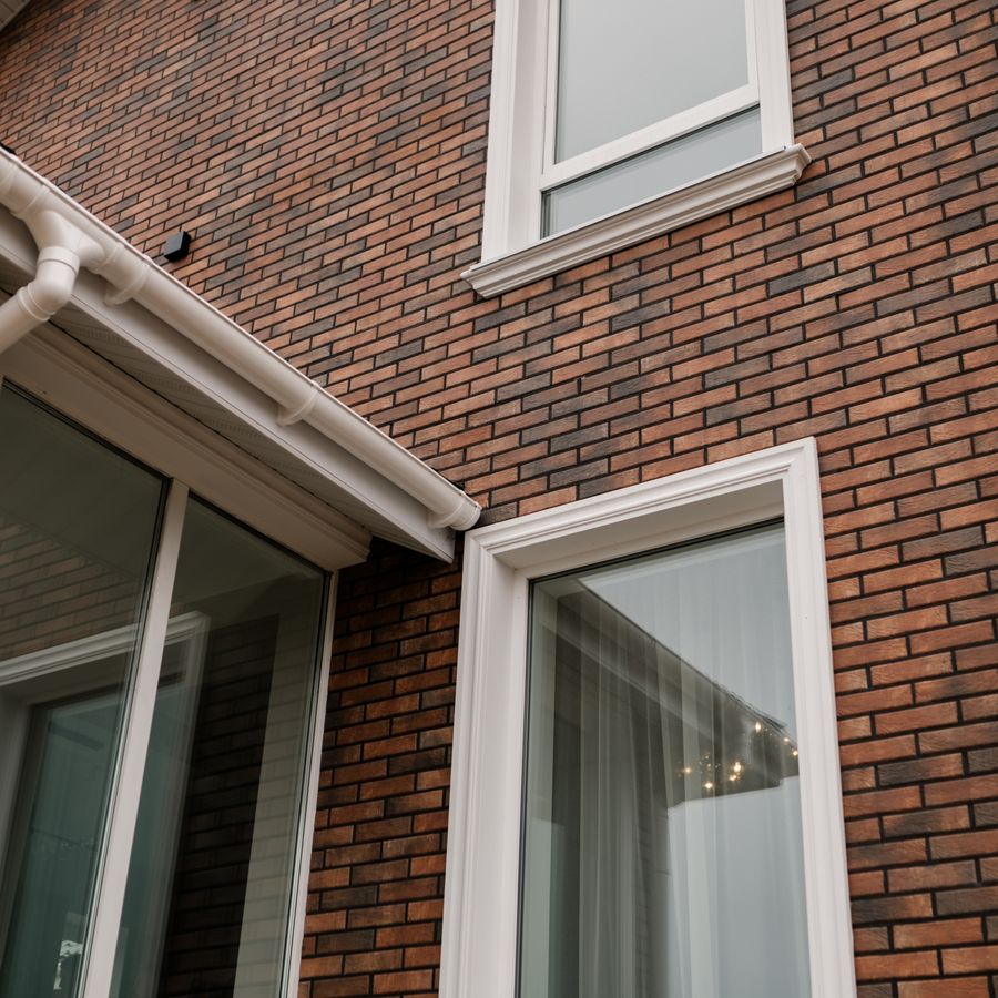 Weiß gerahmtes Kunststofffenster an einem Wohnhaus mit Klinkerfassade