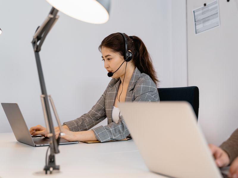 Kundenbetreuung am Arbeitsplatz mit Headset und Notebook